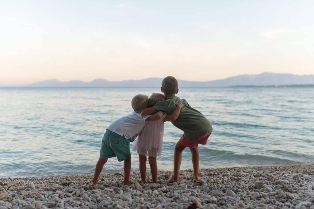 Tres hermanos abrazándose en la playa