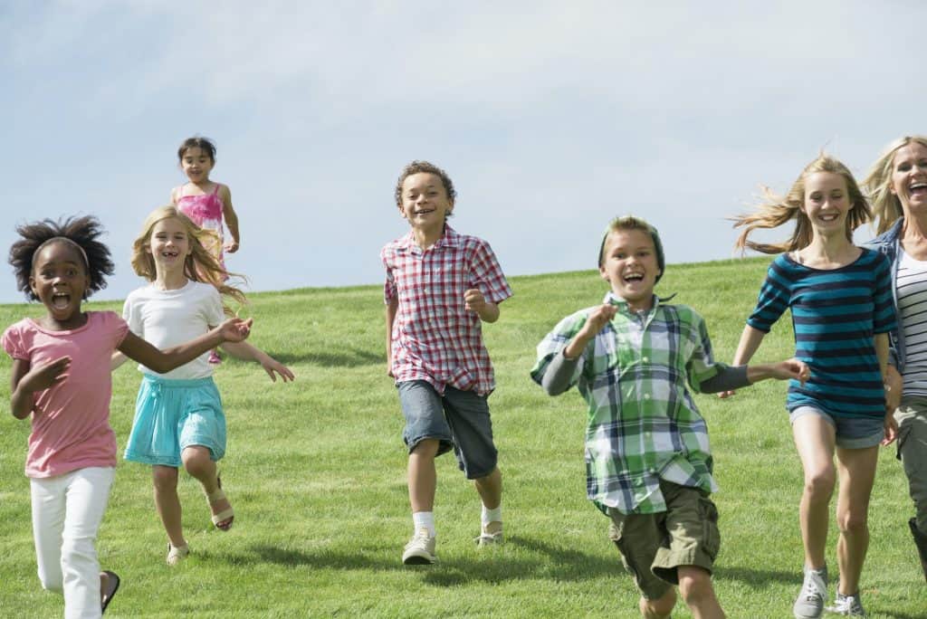 Un grupo de niños corrió por la hierba.