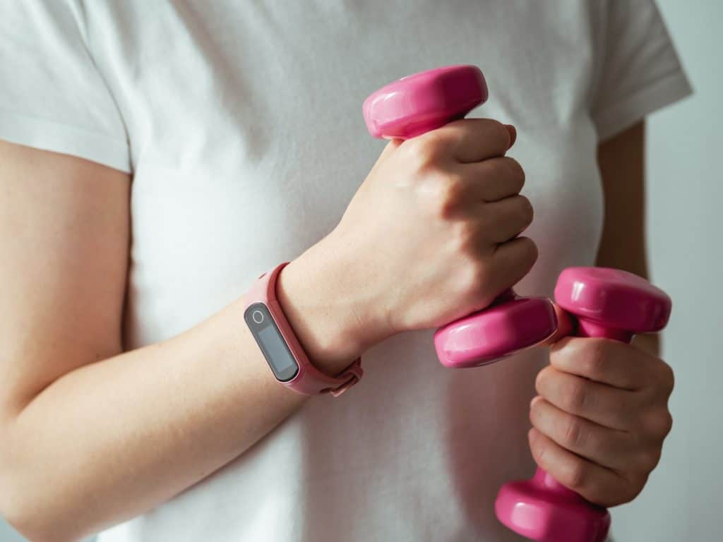Significado de soñar con ejercicio 3 Mujer con rastreador de fitness y barra